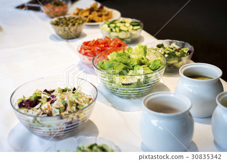 Variety of fresh salads bowls on buffet table 30835342