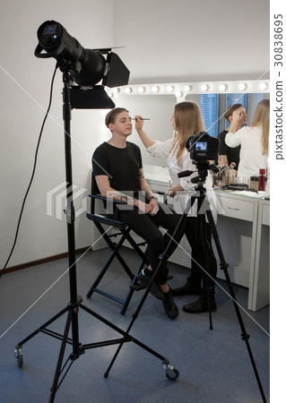 Woman applying male makeup Woman applying male makeup 30838695