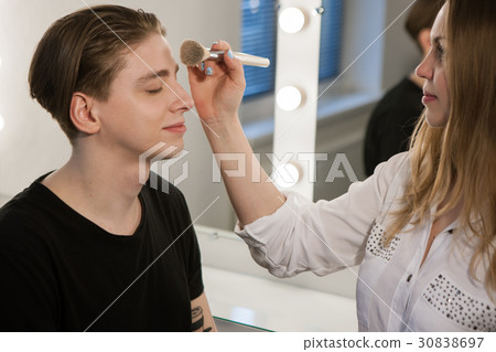 Woman putting makeup on man Woman putting makeup on man 30838697