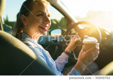 Young businesswoman sending a text message and drinking coffee i Young businesswoman sending a text message and drinking coffee i 30840702