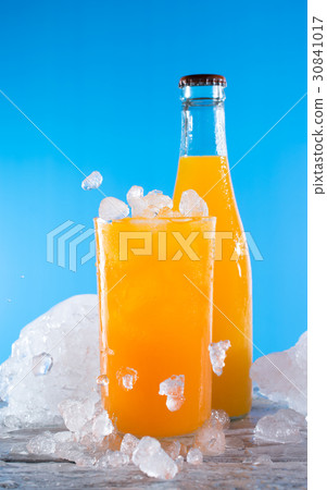 bottle of orange soda with glass and ice on a wood bottle of orange soda with glass and ice on a wood 30841017