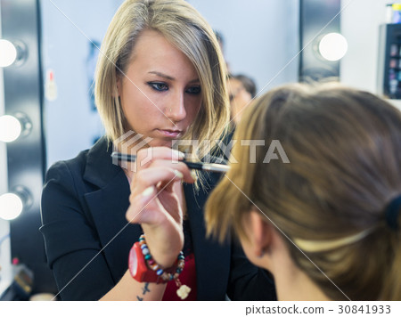 Make-up artist doing smoky eyes makeup to Make-up artist doing smoky eyes makeup to 30841933