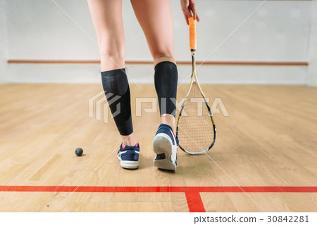 Squash game female player legs, racket and ball Squash game female player legs, racket and ball 30842281