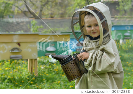 The boy in protective clothing beekeeper works on The boy in protective clothing beekeeper works on 30842888