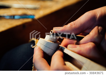 Master artisan luthier working on the creation of 30843671
