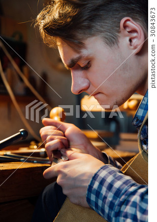 Master artisan luthier working on the creation of 30843673