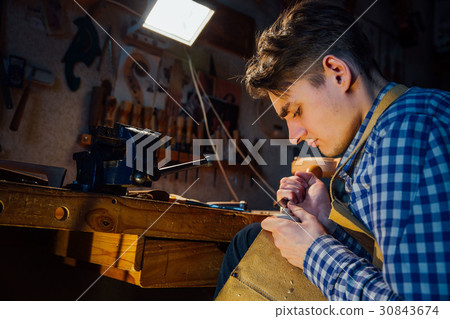 Master artisan luthier working on the creation of 30843674