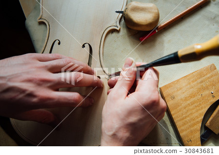 Master artisan luthier working on the creation of Master artisan luthier working on the creation of 30843681