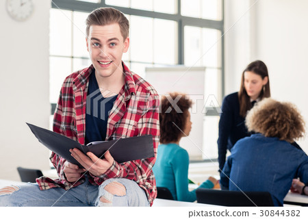 Portrait of a cheerful student holding an open 30844382