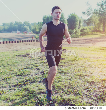 Fit man running outdoor in nature on beach Morning Fit man running outdoor in nature on beach Morning 30844406