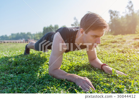 Athlete doing a plank exercise on sunny day Athlete doing a plank exercise on sunny day 30844412