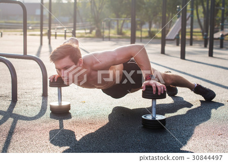 Young muscular male athlete doing push-up Young muscular male athlete doing push-up 30844497
