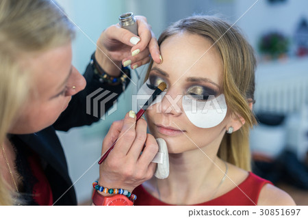 Make-up artist doing smoky eyes makeup to Make-up artist doing smoky eyes makeup to 30851697