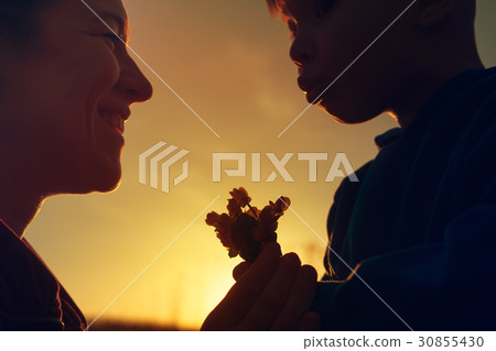 Mother and child with spring flowers at sunset 30855430
