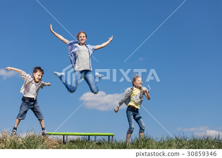 Brother and sisters playing on the field at the day time. Brother and sisters playing on the field at the day time. 30859346