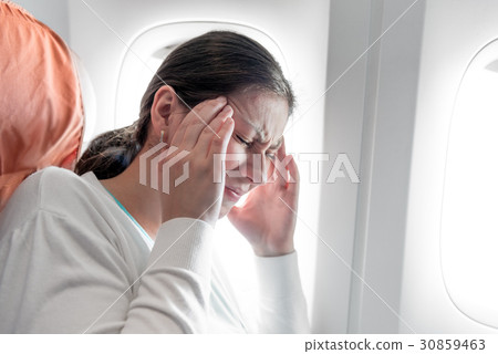 Portrait of a woman with a headache on an airplane 30859463