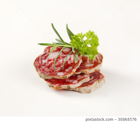 slices of dry cured salami with herbs 30868576