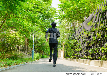 A businessman standing on the road of fresh green A businessman standing on the road of fresh green 30868740