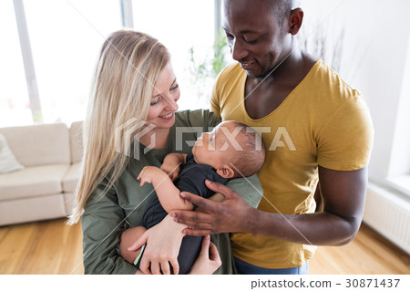 Young interracial family with little baby son at 30871437