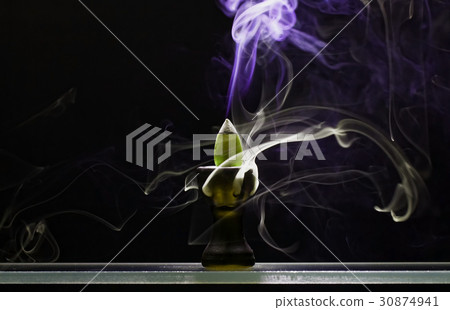 Aromatic cone smoldering in a ceramic stand 30874941