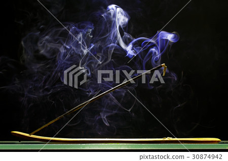 Incense stick smolders and emits intensive smoke 30874942