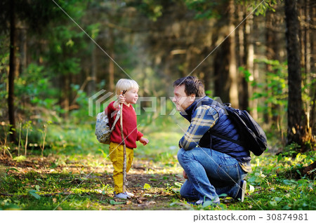 Father and his son walking during the hiking activities in forest Father and his son walking during the hiking activities in forest 30874981