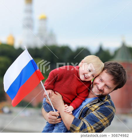 Family with russian flag with Moscow Kremlin on background Family with russian flag with Moscow Kremlin on background 30874982