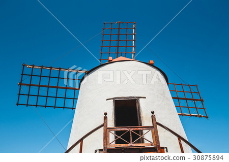 Windmill on blue sky background in cactus garden 30875894