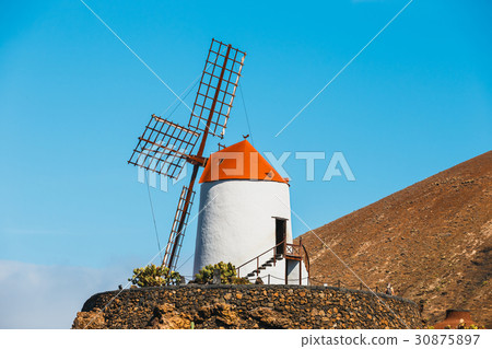 Windmill on blue sky background in cactus garden 30875897