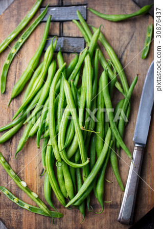 圖庫照片: green beans on wooden cutting board. top view