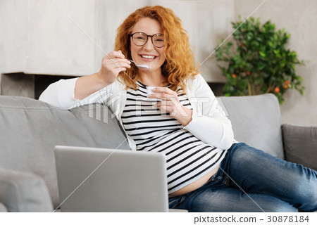 Thrice happy pregnant woman eating yoghurt 30878184