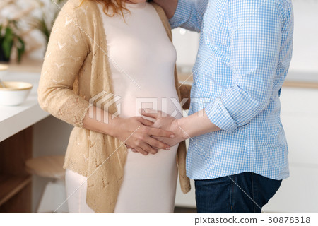 Close up of married couple touching baby bump 30878318