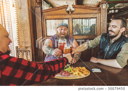 Joyful bearded guys resting in bar Joyful bearded guys resting in bar 30879450