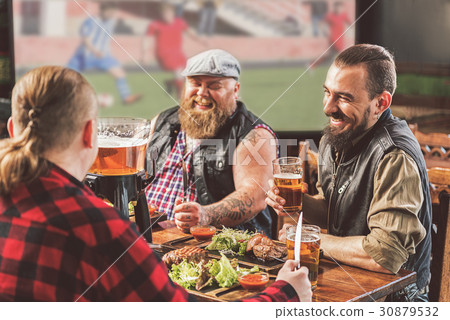 Positive pleasant men having dinner in bar 30879532