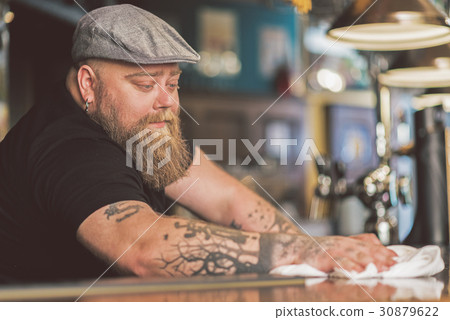 Serious bearded guy working meditatively Serious bearded guy working meditatively 30879622