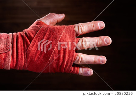 Close-up image of boxer's hand with a red bandage Close-up image of boxer's hand with a red bandage 30880236