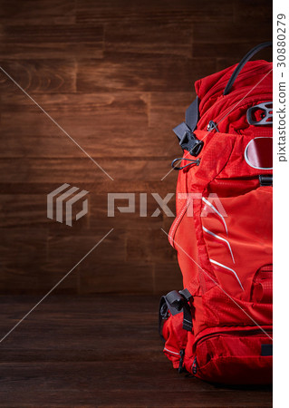 Big orange tourist backpack on the wooden Big orange tourist backpack on the wooden 30880279