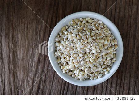 pearl barley in white bowl on wood 30881423