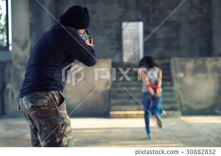 Man in balaclava threatening with gun to woman 30882832