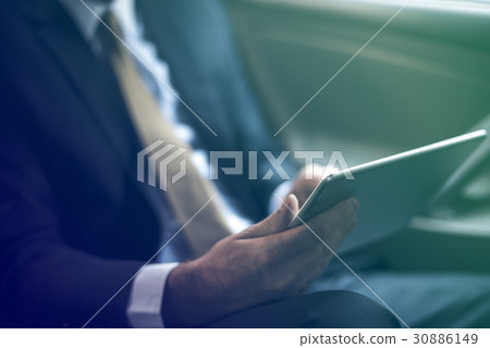 Businessman using digital tablet on backseat of the car 30886149