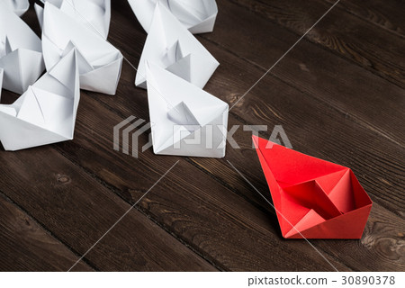 Business leadership concept with white and color paper boats on wooden table Business leadership concept with white and color paper boats on wooden table 30890378