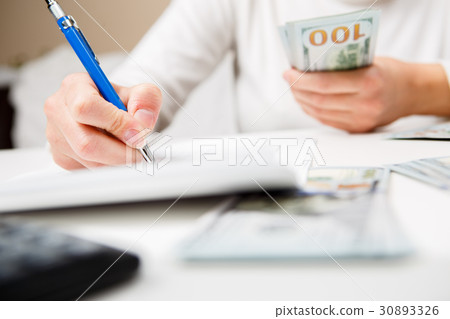 Entrepreneur calculating and reviewing investment Entrepreneur calculating and reviewing investment 30893326