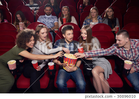 Friends pulling hands to popcorn of one shocked Friends pulling hands to popcorn of one shocked 30896010