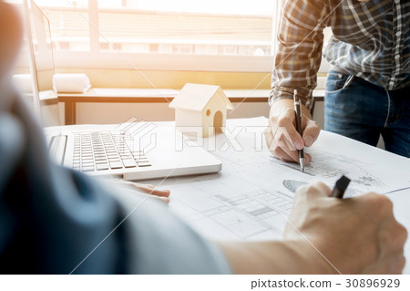 Architects engineer discussing at the table with blueprint - Clo Architects engineer discussing at the table with blueprint - Clo 30896929