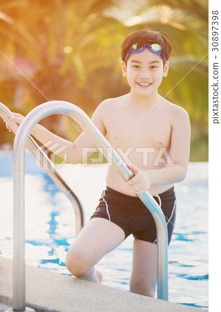 Happy asian boy in swimsuit coming up the pool 30897398