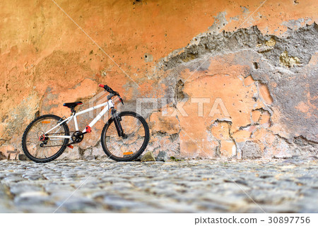 Bicycle near a stone wall 30897756