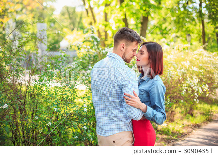 Happy young couple at park standing and laughing Happy young couple at park standing and laughing 30904351