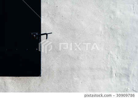 Close up of a black shutter on a white wall Close up of a black shutter on a white wall 30909786