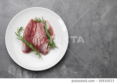 Raw duck breast in white plate 30910013