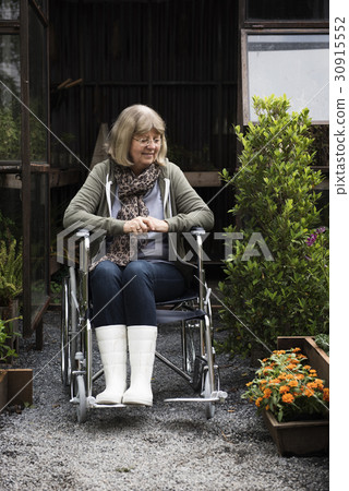 Senior Adult Woman Sitting on Wheelchair in a Park 30915552